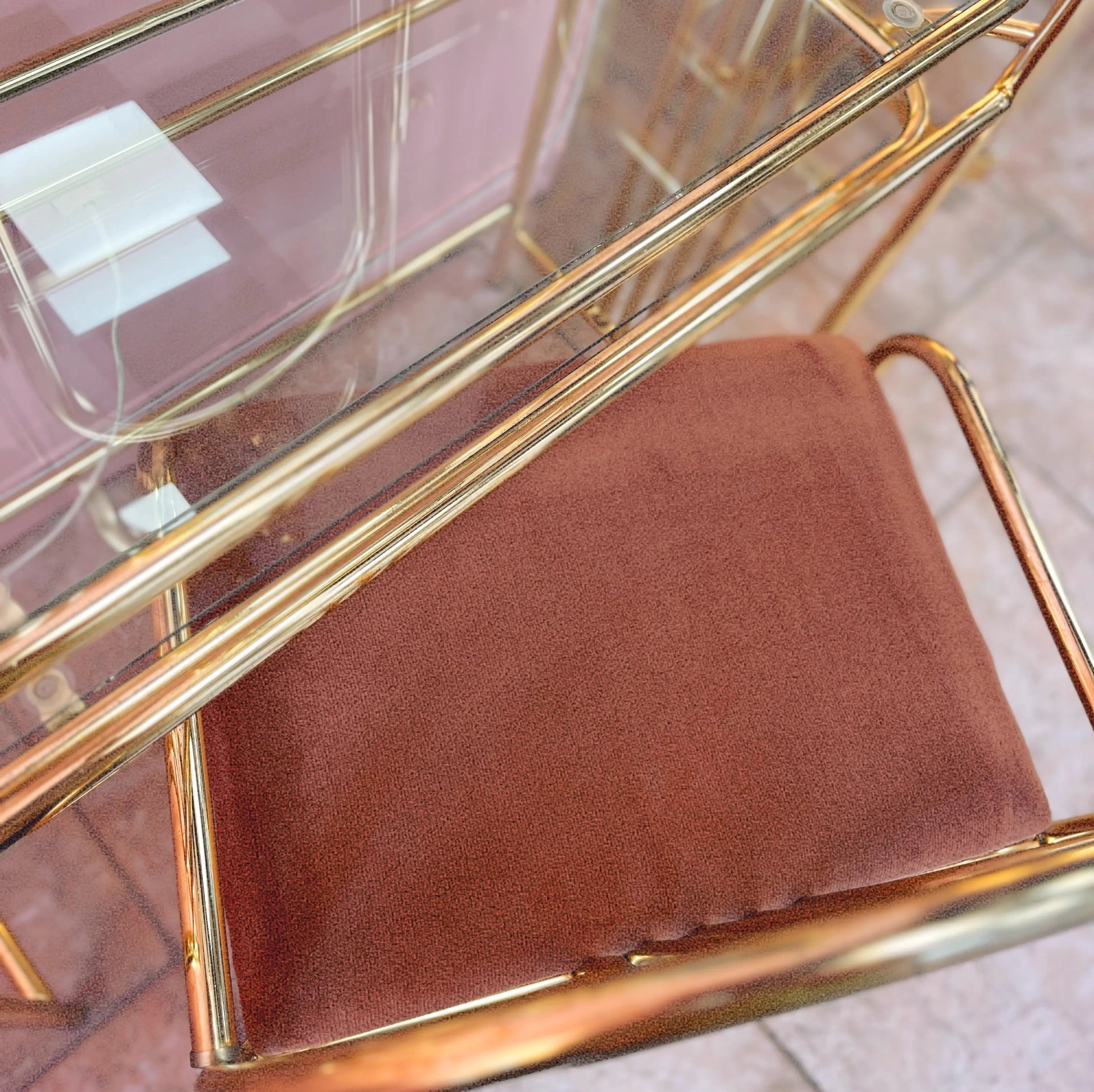 Fauteuil vintage en velours rose avec structure en laiton, au design élégant et rétro, idéal pour une touche chic et colorée dans un intérieur.
