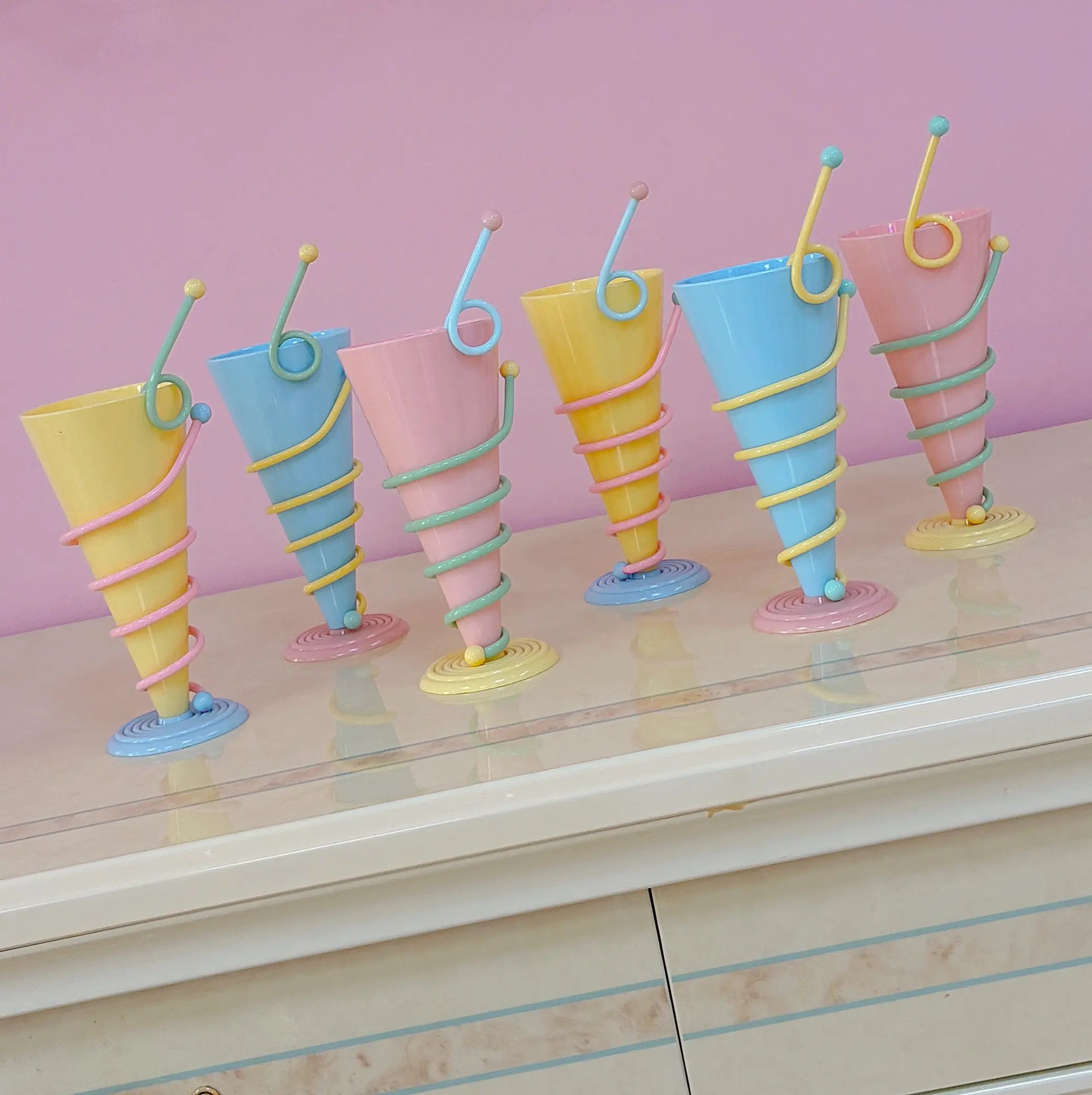Ensemble de six coupes coniques en trois coloris pastels, pied en spirale concentrique, années 1980
